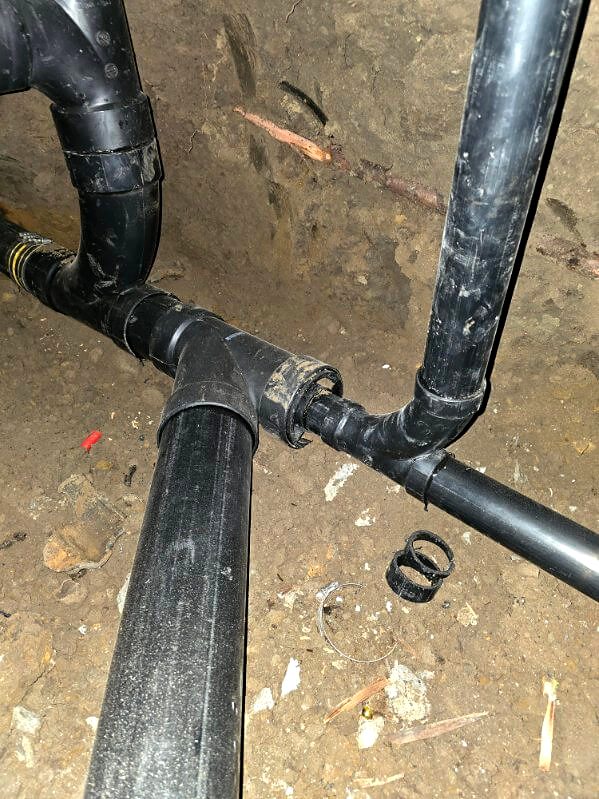New black ABS drain line fittings installed underground